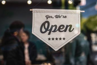 Open sign hanging in restaurant window